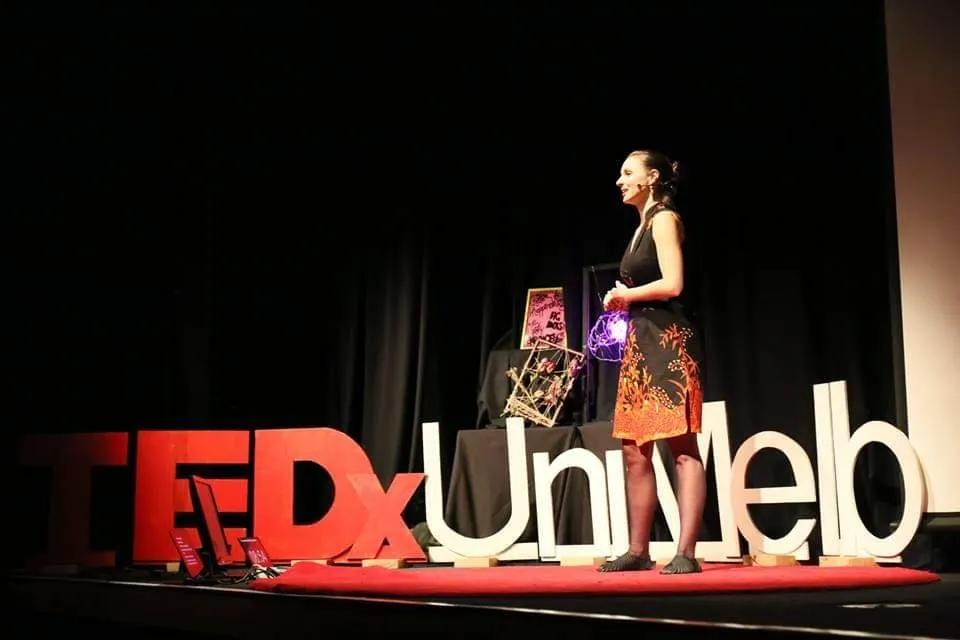 Daria speaking on the TEDx stage.